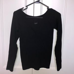 Black v-neck form fitting sweater.